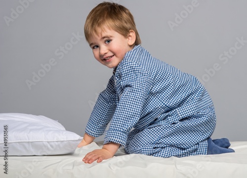 Photo: Little boy wearing blue pyjamas in bed Little boy wearing blue pyjamas in bed