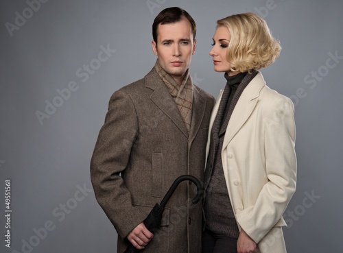 Photo: Elegant couple with umbrella isolated on grey Elegant couple with umbrella isolated on grey