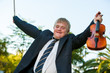 Friendly handicapped boy raising violin outdoors.