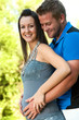 Young husband touching wife's pregnant tummy.