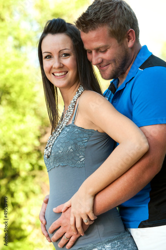 Photo: Young husband touching wife's pregnant tummy. Young husband touching wife's pregnant tummy.