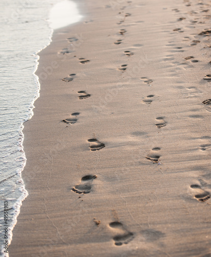 Photo: Footsteps of couple on the beach by the sea in summer Footsteps of couple on the beach by the sea in summer