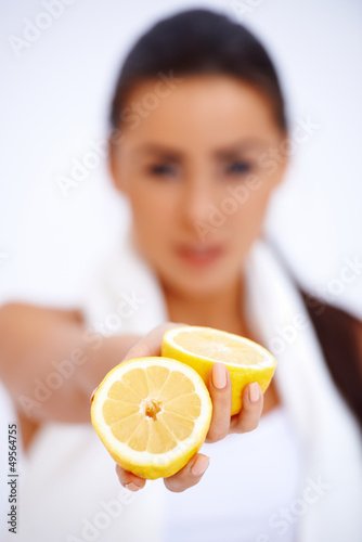 Photo: Close up of a woman showing fresh lemon Close up of a woman showing fresh lemon