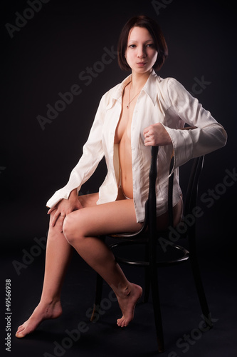 Photo: young sexy woman in white shirt on chair young sexy woman in white shirt on chair