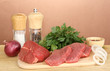 Raw beef meat with spices on wooden table on brown background