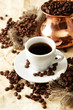 Cup and pot of coffee on beige background