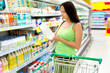 The woman the buyer in shop chooses milk