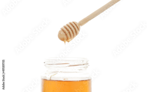 Photo: honey and honey stick over white honey and honey stick over white