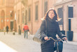 Woman riding bicycle in Bologna, Italy.