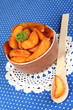 Appetizing village potatoes in bowl on blue fabric close-up
