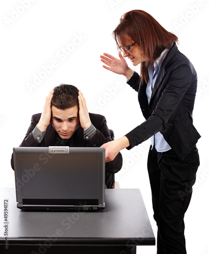Photo: Angry businesswoman showing her emplyee the mistakes on a laptop Angry businesswoman showing her emplyee the mistakes on a laptop