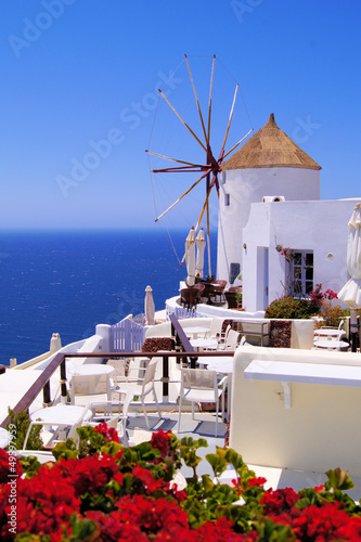 Photo: Famous windmill of Santorini, Greece with red flowers Famous windmill of Santorini, Greece with red flowers