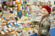 Mature woman chooses sweets