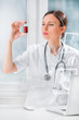 Portrait of pretty female laboratory assistant analyzing a blood