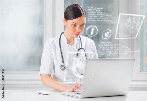 Photo: Pretty female medicine doctor working with modern computer inter Pretty female medicine doctor working with modern computer inter