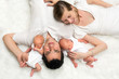Sleeping twins with parents