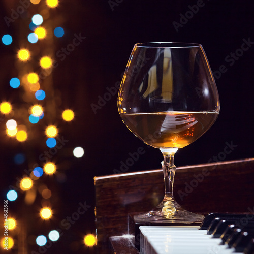 Photo: snifter with brandy on a piano snifter with brandy on a piano