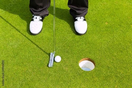 Photo: Golf player putting ball in hole Golf player putting ball in hole