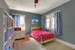 Kids bedroom with red bed and grey walls.