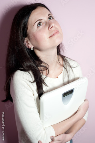 Photo: The smiling girl holds floor scales The smiling girl holds floor scales