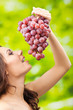 Young happy smiling woman with grapes, outdoors