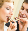 Cheerful couple eating cookies