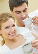 Photo: Cheerful couple with cups of coffee, indoor Cheerful couple with cups of coffee, indoor