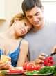 Cheerful young cooking couple at home