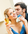 Cheerful amorous couple with gifts, indoors