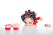 Junge Frau schielt auf Cupcakes im Pinup Style
