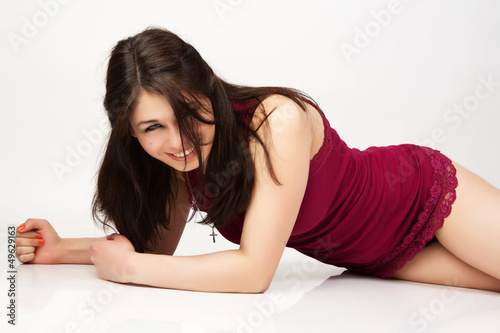 Photo: Beautiful woman in the red jersey sits on the floor. Beautiful woman in the red jersey sits on the floor.