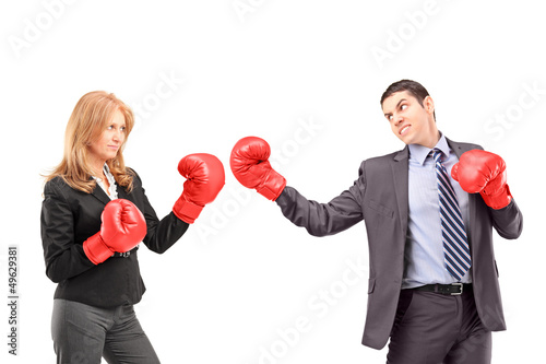 Photo: Businesswoman with boxing gloves having a fight with a businessm Businesswoman with boxing gloves having a fight with a businessm