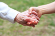 Senior and Young Women Holding Hands