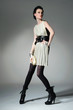 Photo: Studio portrait of a young woman with a purse posing Studio portrait of a young woman with a purse posing