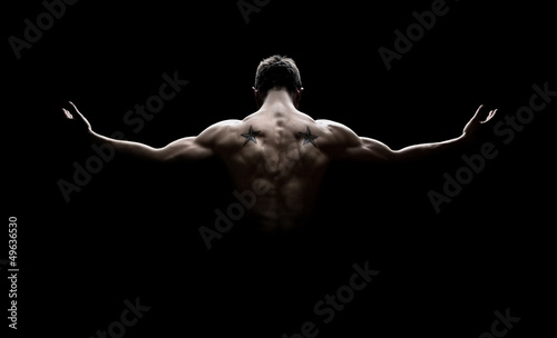 Photo: Rear view of healthy young man with arms stretched out Rear view of healthy young man with arms stretched out