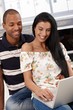 Happy couple with laptop computer at home