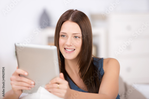 Photo: lächelnde frau liest am tablet-pc lächelnde frau liest am tablet-pc