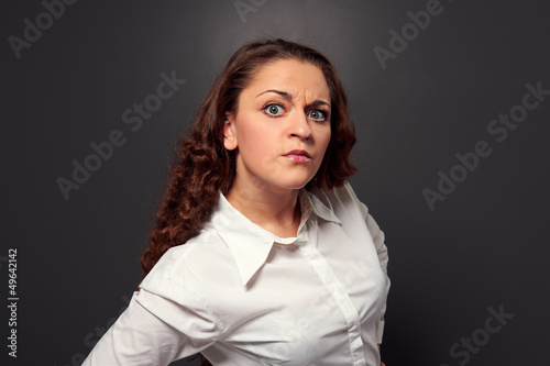 Photo: studio shot of curly woman looking at camera studio shot of curly woman looking at camera