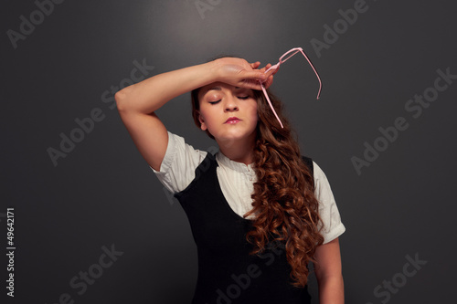 Photo: tired young woman holding glasses tired young woman holding glasses