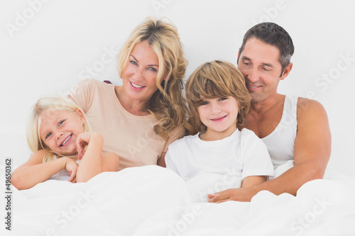 Photo: Family lying on a white bed Family lying on a white bed