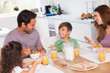 Family laughing around breakfast