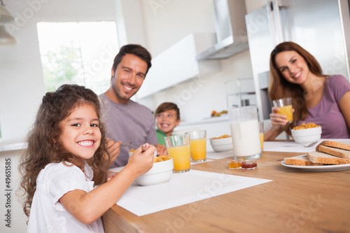 Photo: Family smiling at the camera at breakfast Family smiling at the camera at breakfast