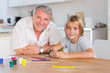 Grandfather and grandson looking at camera with drawings