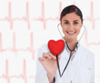 Doctor holding stethoscope up to red heart graphic