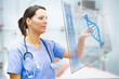 Nurse touching screen displaying blue DNA helix
