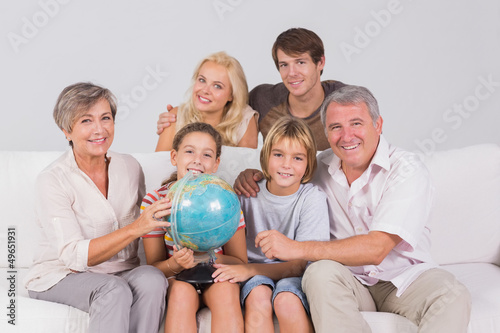 Photo: Family portrait looking at camera with a globe Family portrait looking at camera with a globe