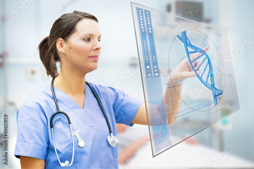 Photo: Nurse touching screen displaying blue DNA helix Nurse touching screen displaying blue DNA helix