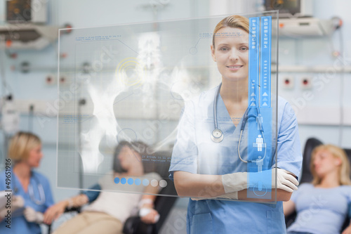Photo: Nurse standing with arms crossed next to patients Nurse standing with arms crossed next to patients