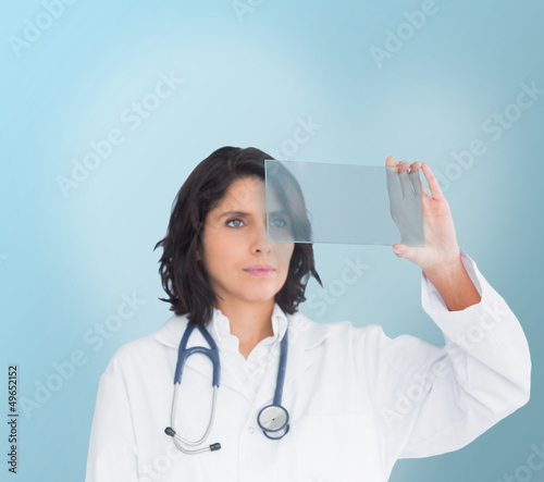 Photo: Brunette doctor looking at a screen Brunette doctor looking at a screen