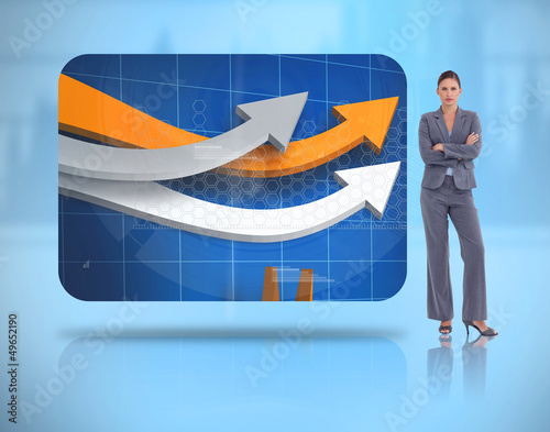 Photo: Businesswoman crossed arms near to a digital interface Businesswoman crossed arms near to a digital interface